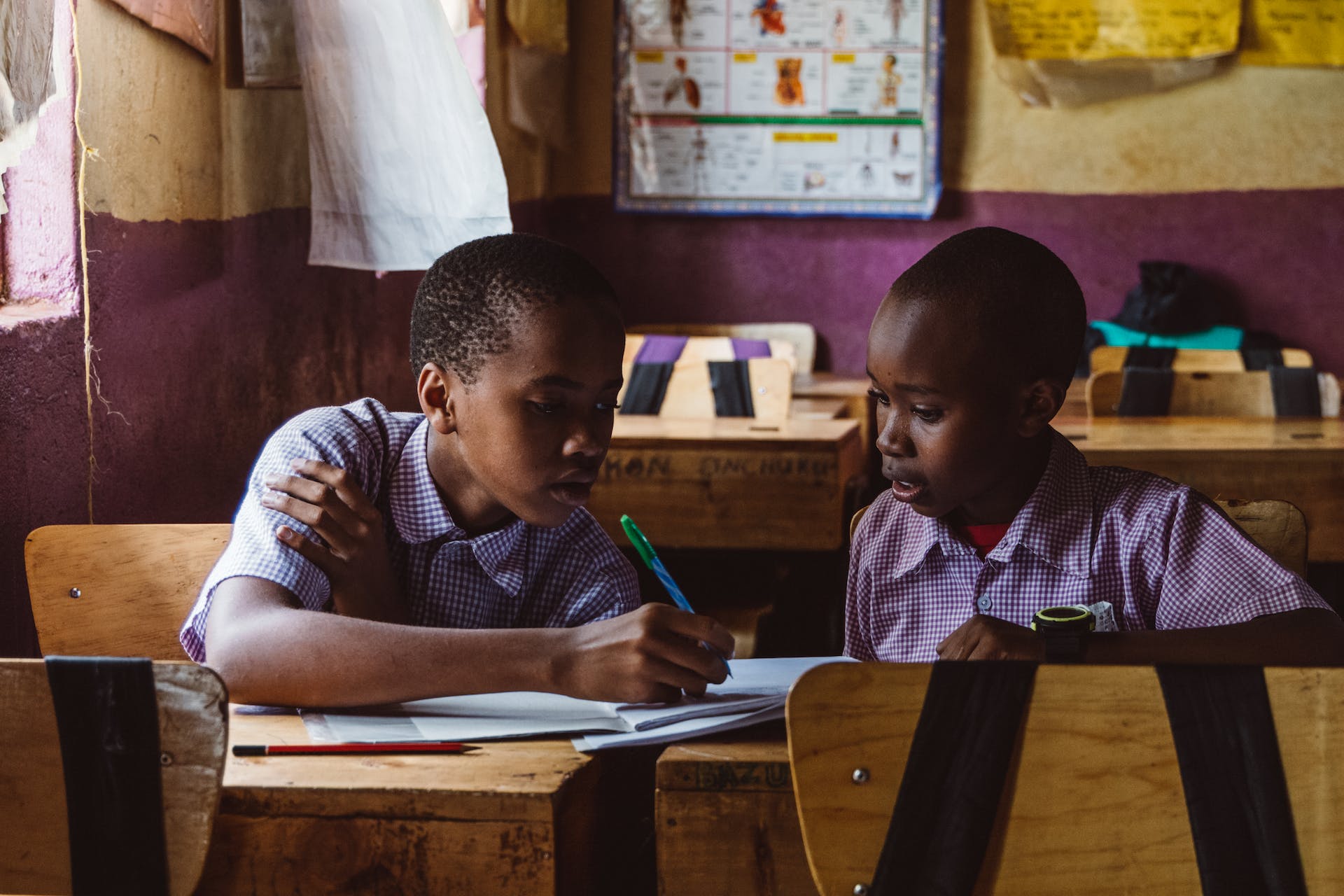 Two boys reading and studying in a classroom.